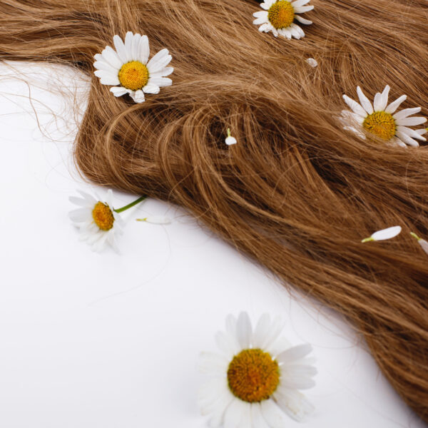Little white flowers lie on the brown hair curls